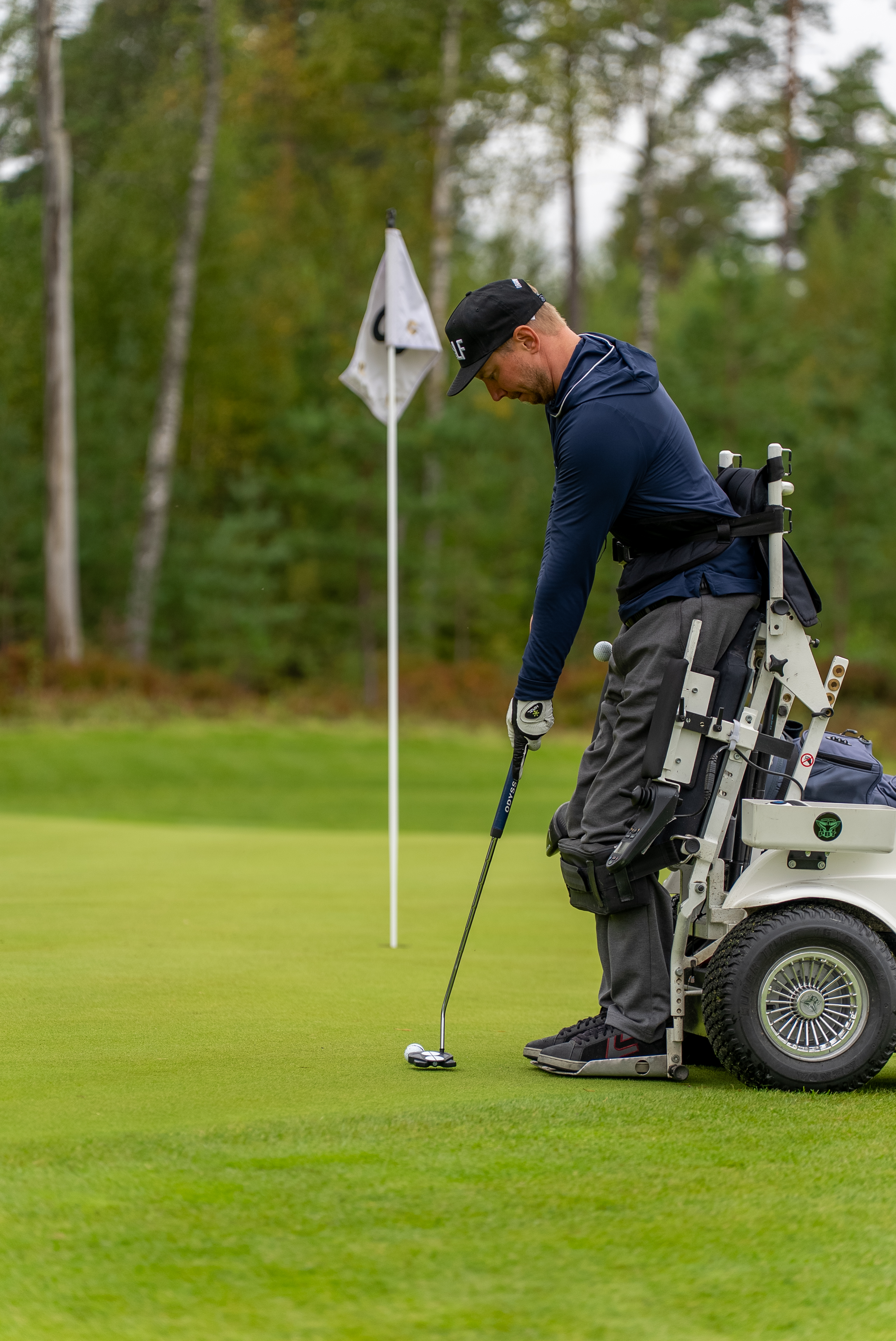 Kuvassa henkilö puttaa palloa viheriöllä paragolferista,